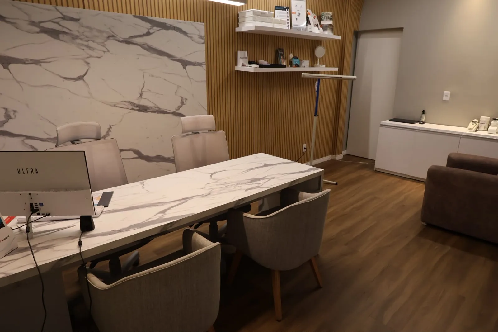 Consultório da Audio Senses com mesa de mármore e painel ripado