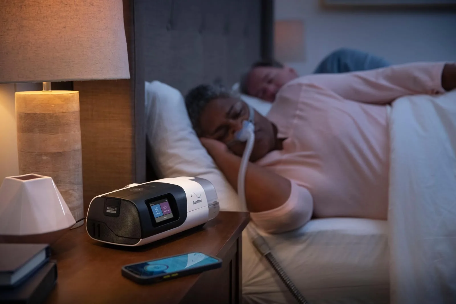 CPAP ResMed AirSense 11 na mesa de cabeceira enquanto o paciente dorme